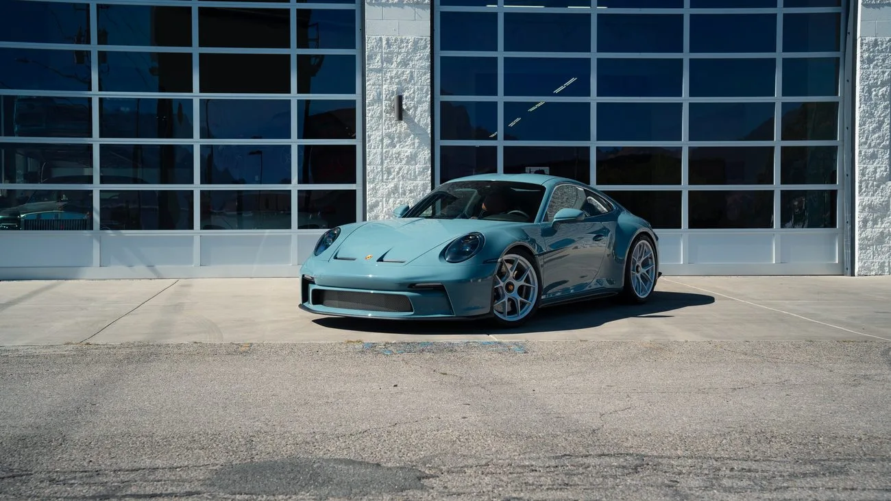 Tinted sports car in the sun outside the shop